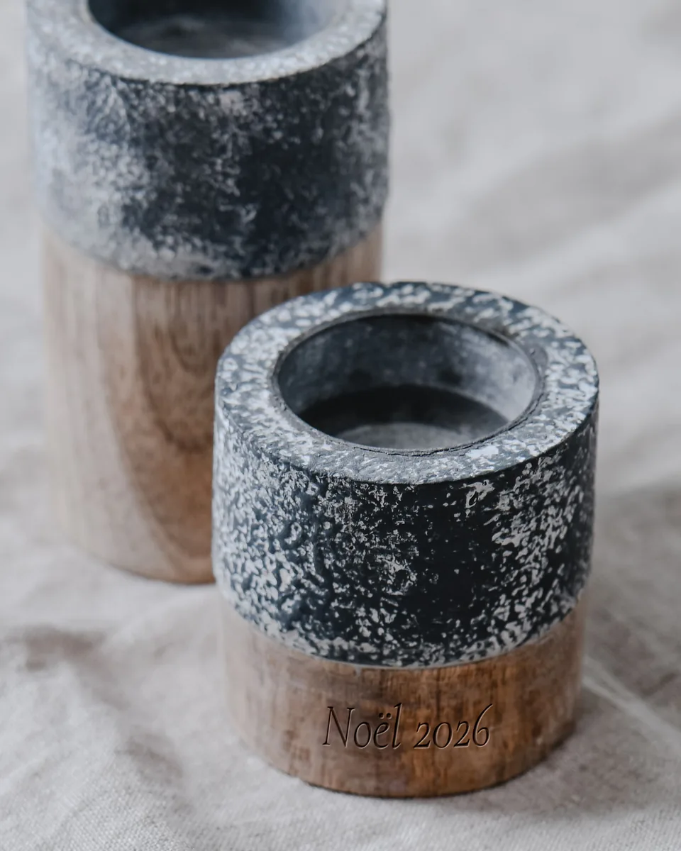 Photophore en pierre mouchetée sur un fût de bois, gravé « Noël 2026 » sur la ceinture de bois