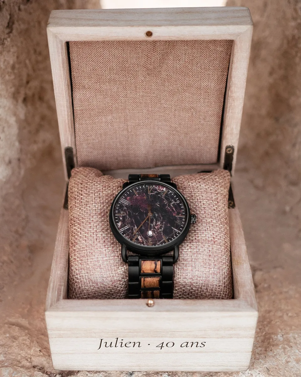Écrin à montre en bois clair, ouvert sur une montre, façade gravée « Julien · 40 ans »