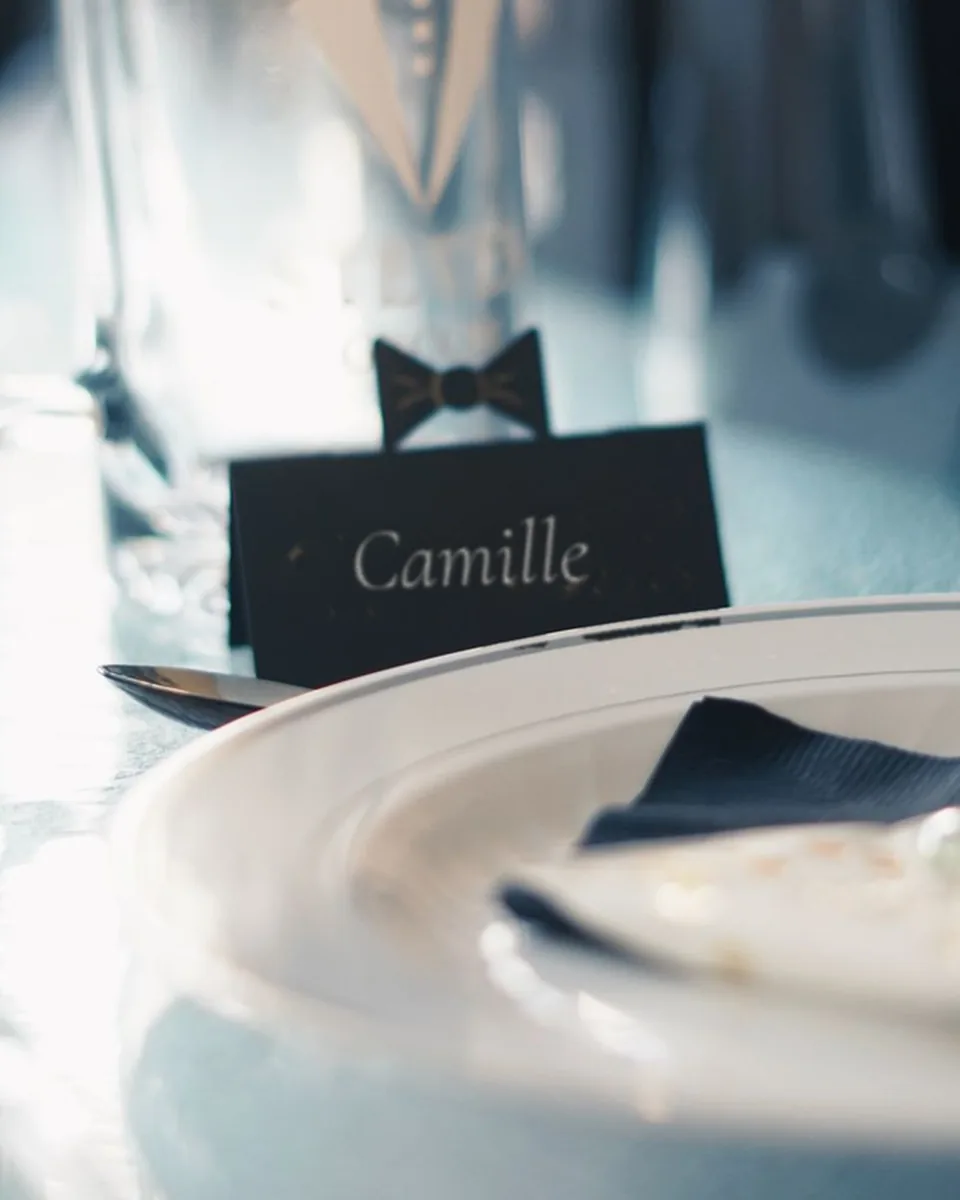 Marque-place noir gravé « Camille », sur une table de mariage