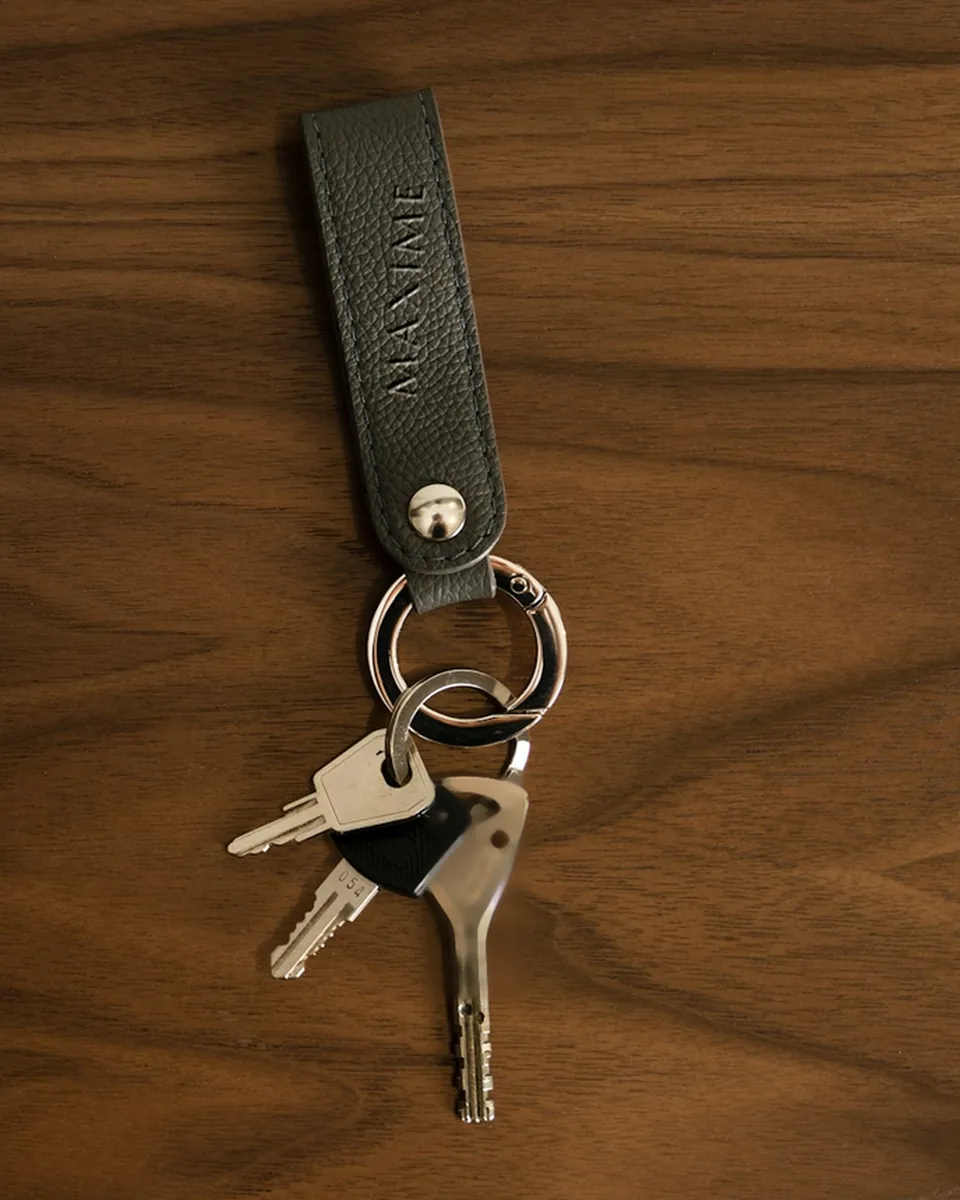 Porte-clés en cuir gravé MAXIME, sur une table en noyer