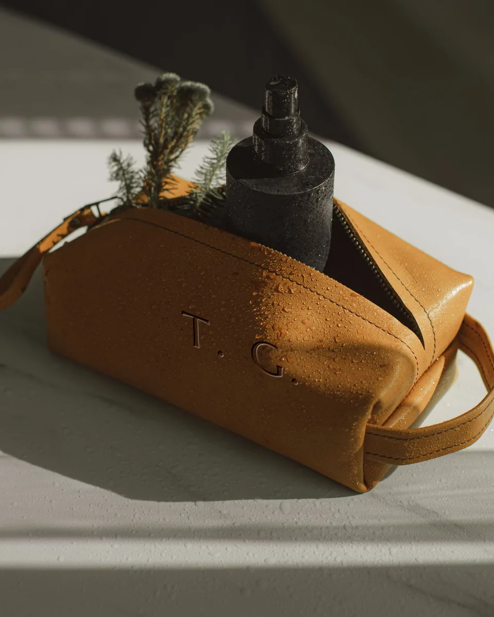 Trousse de toilette en cuir fauve perlée d'eau, gravée T. G.