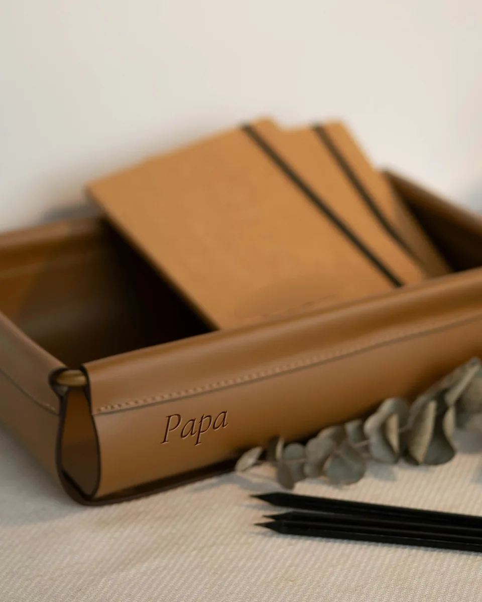 Vide-poche de cuir fauve à coins pressionnés, gravé « Papa » sur la paroi, des carnets à l'intérieur