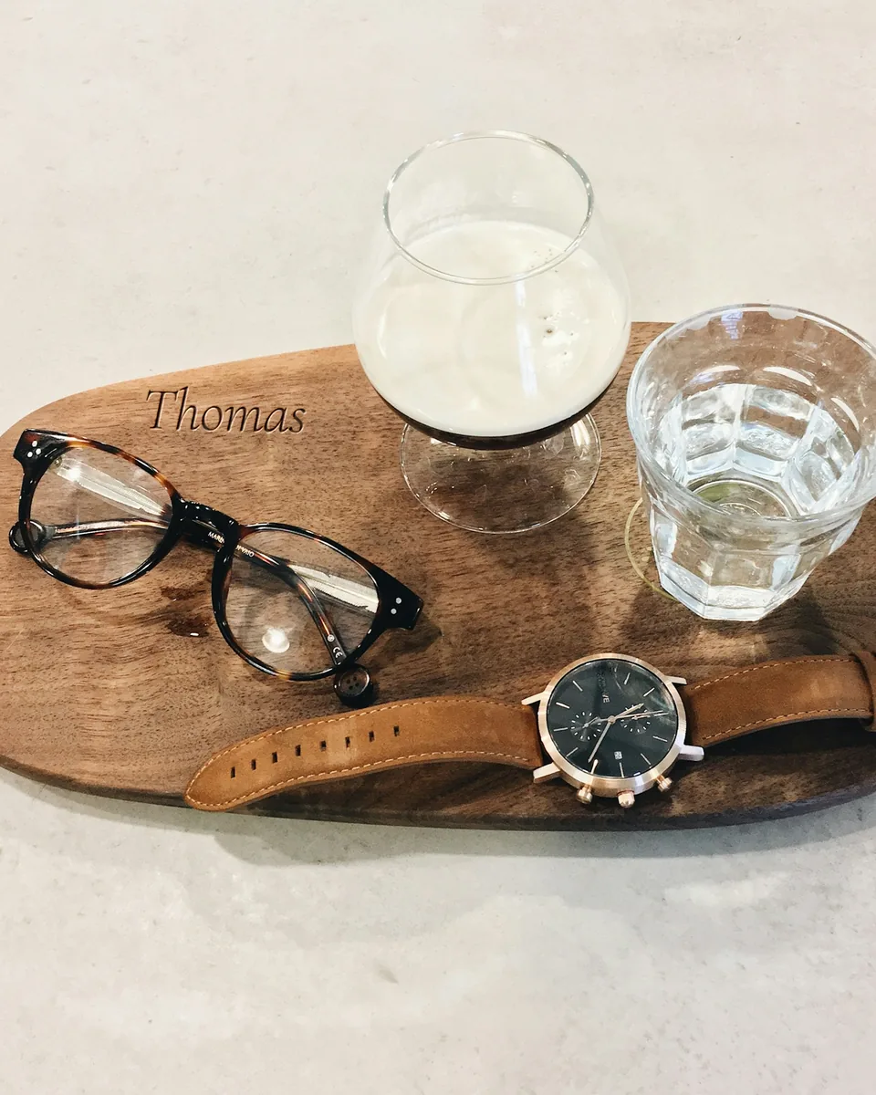 Plateau vide-poche en noyer gravé « Thomas », avec des lunettes, une montre et deux verres